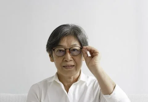 Old smart lady doing activity for relax time at living room 写真素材