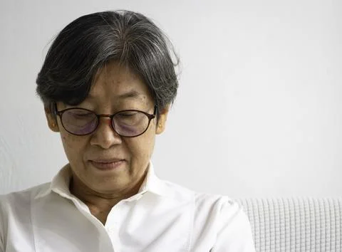 Old smart lady doing activity for relax time at living room Foto stock