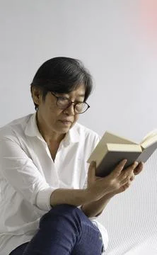 Old smart lady doing activity for relax time at living room 写真素材