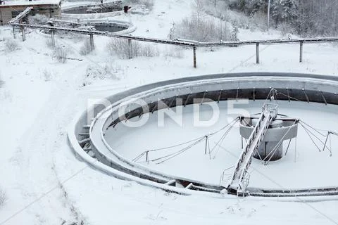Old snow-covered empty round settler in sewerage plant Stock Photos