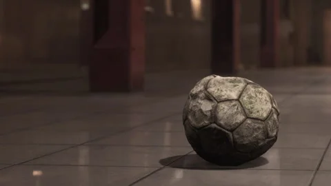 Old soccer ball on a tiled floor in an empty, indoor sports hall Stock Footage 344969452