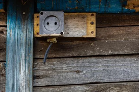 An old socket with a cut wire nailed to a wooden building Stock Photos