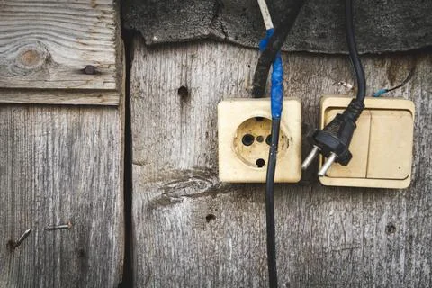 Old socket. Switch and socket. Broken electrical appliances. Dangerous wires. Stock Photos