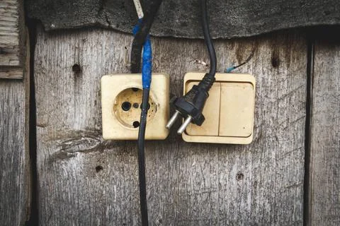 Old socket. Switch and socket. Broken electrical appliances. Dangerous wires. Stock Photos