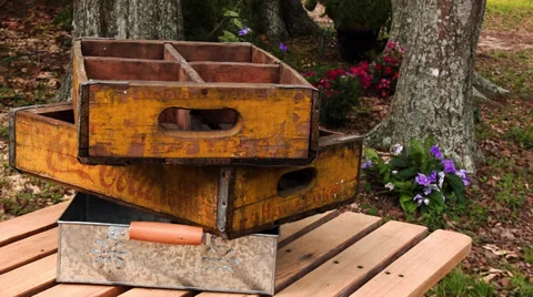 Old soda crates in a stack with flowers in the background Video stock 37878657