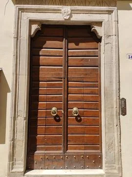 Old solid wood door with Latin sign on the travertine beam Stock Photos