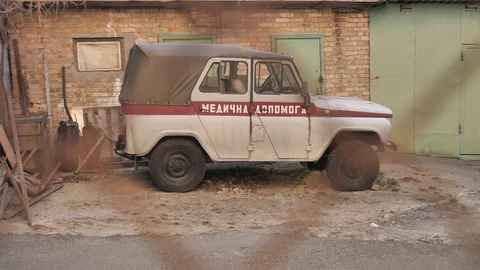 Old, soviet Ambulance car behind the hospital fence. Ukraine, Kyiv, April 2020. Stock Footage 128271668