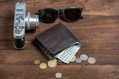 .old Soviet camera and leather wallet with dollars and sunglasses on a wooden Stock Photos