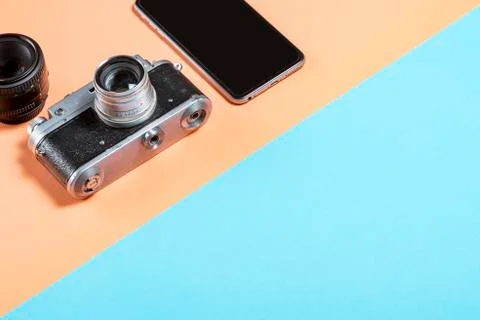 Old Soviet camera with a smartphone and lens on a pink-blue background Foto stock