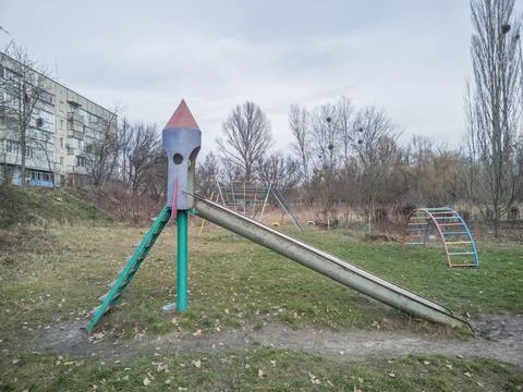 An old Soviet metal slide in the shape of a rocket on a playground Stock Photos