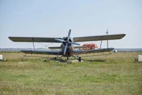 An old Soviet plane is standing in a field not a green meadow Stock Photos