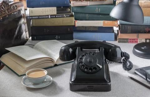 Old Soviet telephone on the table with second-hand books in the background... Stock Photos