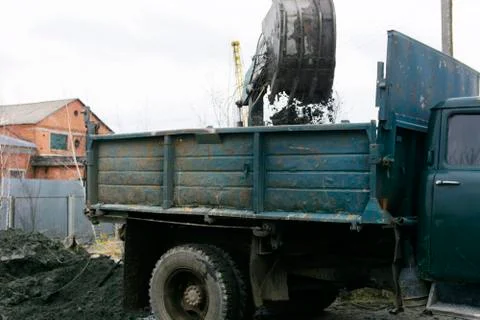 An old Soviet tractor digs and loads waste stone processing near the shop 스톡 사진