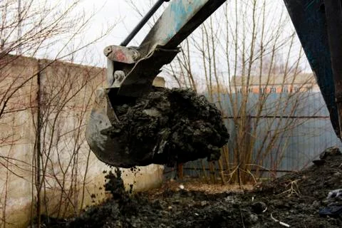 An old Soviet tractor digs and loads waste stone processing near the shop 스톡 사진