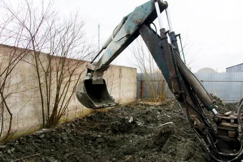An old Soviet tractor digs and loads waste stone processing near the shop Stock Photos