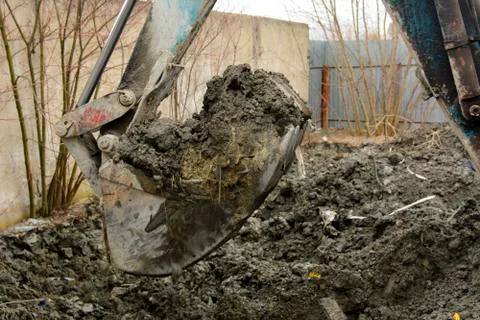 An old Soviet tractor digs and loads waste stone processing near the shop 스톡 사진