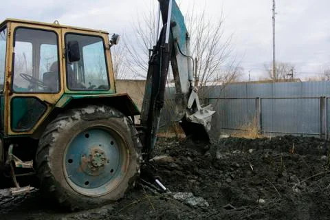 An old Soviet tractor digs and loads waste stone processing near the shop 스톡 사진