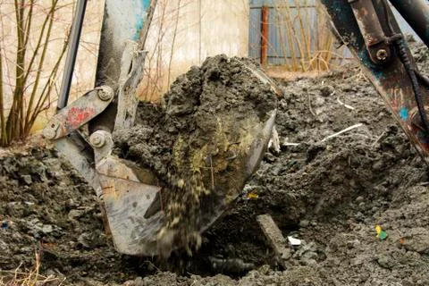 An old Soviet tractor digs and loads waste stone processing near the shop 스톡 사진