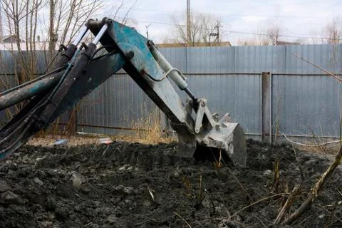 An old Soviet tractor digs and loads waste stone processing near the shop Stock Photos