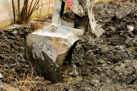 An old Soviet tractor digs and loads waste stone processing near the shop Stock Photos