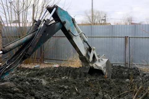 An old Soviet tractor digs and loads waste stone processing near the shop 스톡 사진