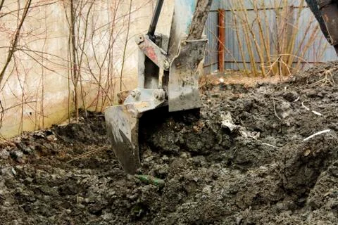An old Soviet tractor digs and loads waste stone processing near the shop Stock Photos