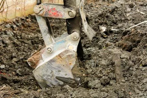 An old Soviet tractor digs and loads waste stone processing near the shop Stock Photos