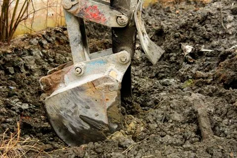An old Soviet tractor digs and loads waste stone processing near the shop Foto stock