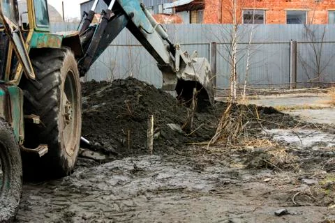 An old Soviet tractor digs and loads waste stone processing near the shop Foto stock