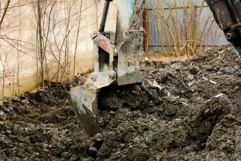 An old Soviet tractor digs and loads waste stone processing near the shop Stock Photos