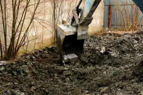 An old Soviet tractor digs and loads waste stone processing near the shop Foto stock