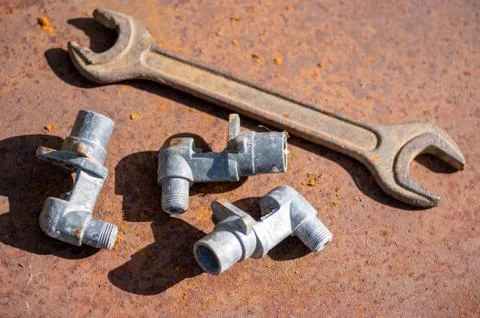 Old spanner on aOld wrench and metal parts on a rusty sheet of metal, close-u Stock Photos