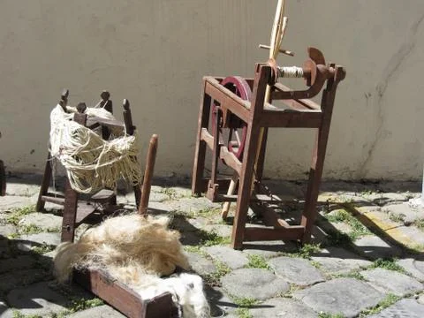 Old spinning wheel, raw wool yarn and wool to card Stock Photos