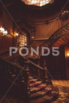 Old spiral wooden staircase with vintage railing indoors. luxury carved wood Stock Photos