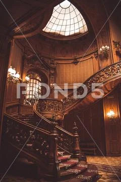 Old spiral wooden staircase with vintage railing indoors. luxury carved wood Stock Photos