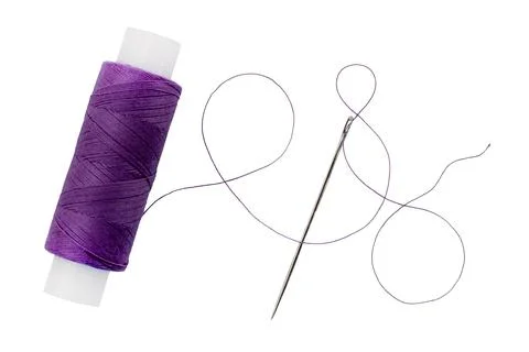 Old spool of thread and needle on a white background. Sewing accessories Foto stock
