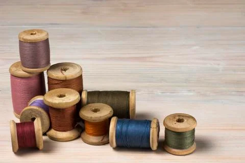 Old spools of thread on wooden background Stock Photos