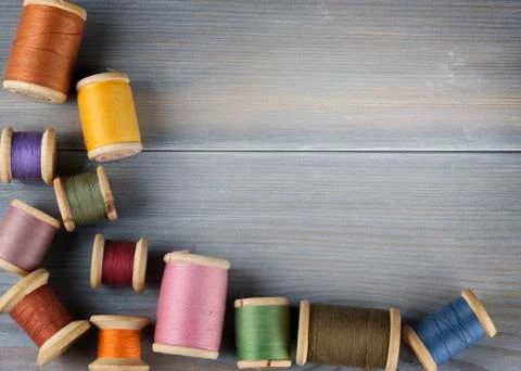 Old spools of thread on wooden background Foto stock