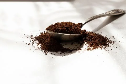 Old spoon with ground coffee in sunlight, aroma of the beginning of the day Stock Photos