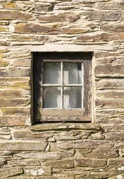 Old square single window and Welsh stone wall. UK Stock Photos