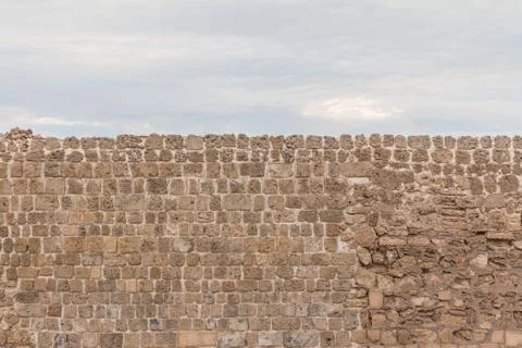 Old stable stone wall with rows of crafted masonry stones. Brickwork with ind Stock Photos
