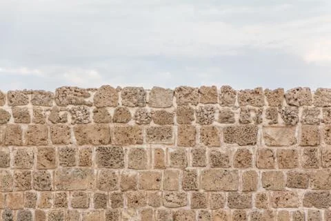 Old stable stone wall with rows of crafted masonry stones. Brickwork with ind Foto stock