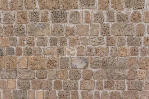 Old stable stone wall with rows of crafted masonry stones. Brickwork with ind Stock Photos