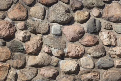 Old stable stone wall with rows of nature masonry stones. Brickwork with indi Stock Photos