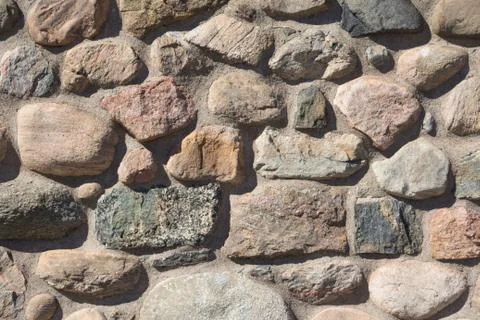 Old stable stone wall with rows of nature masonry stones. Brickwork with indi Foto stock
