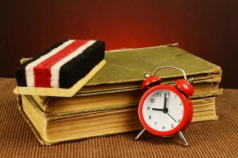 An old stack of books with a chalk eraser and alarm clock made to have a hist Stock Photos