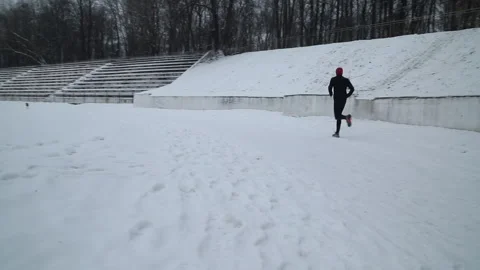 Old stadium in the winter with runner Stock-Footage 166470262