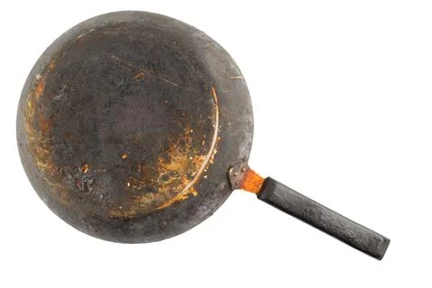 Old stained rusty cast iron pan with burnt fat isolated on white bottom up in Фото