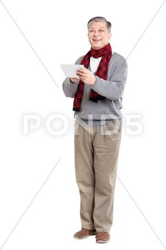 Old standing Asian man in jumper with tablet Stock Photos