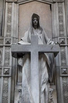 Old statue with cross in cemetery. Dramatic mysterious figure, no people. Stock-Fotos